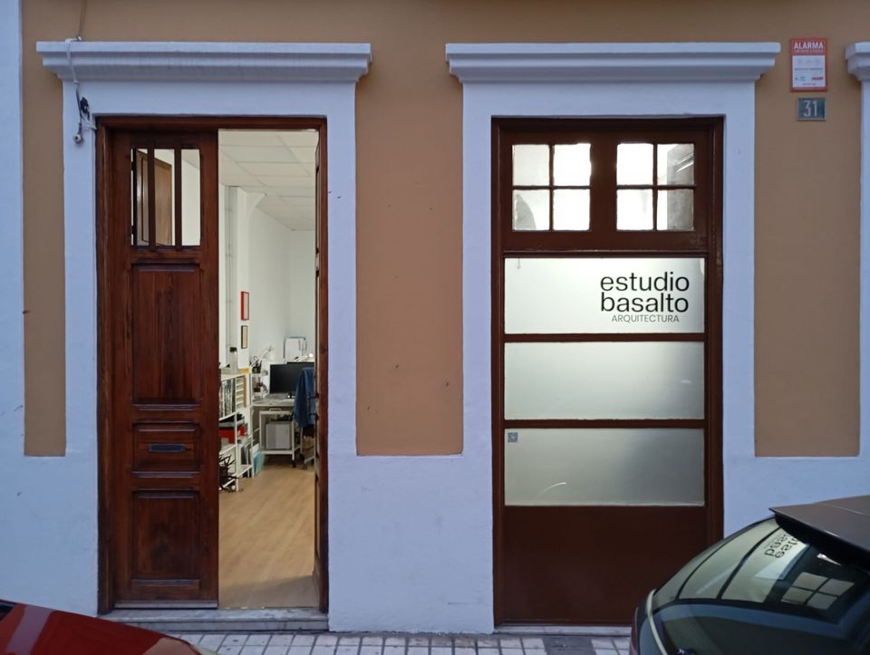 Entrada de estudiobasalto en la calle Senador Castillo Olivares 31, Las Palmas de Gran Canaria, con el rótulo del estudio sobre el vidrio y la puerta de acceso abierta.